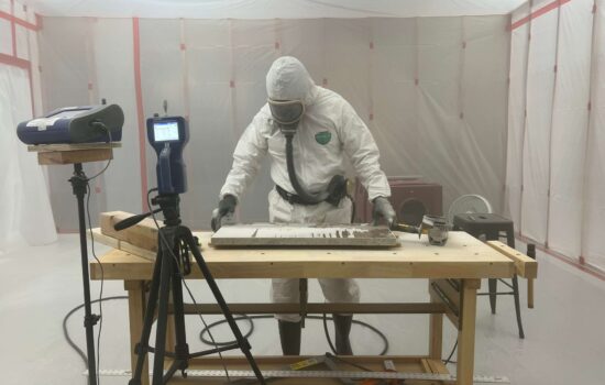 a man in a hazmat suit is working on a piece of wood