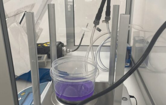 a purple liquid is in a plastic container on a scale